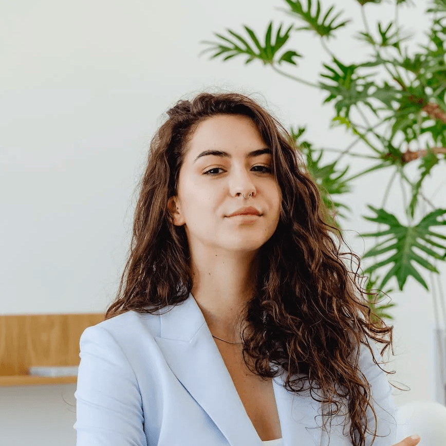 woman in white in office with a plant behind
