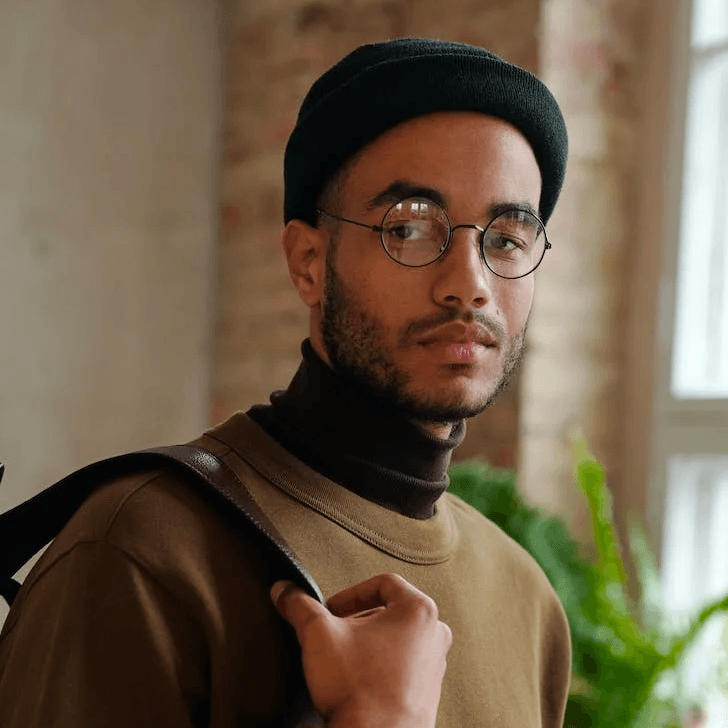 man with glasses in office with a plant behind